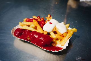 Pommes mit Currywurst, Ketchup und Mayonese